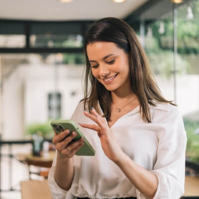 Jeune femme tenant son téléphone dans ses mains.